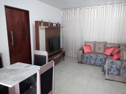 - un salon avec un canapé et une télévision dans l'établissement Casa Martins, à São Miguel dos Milagres