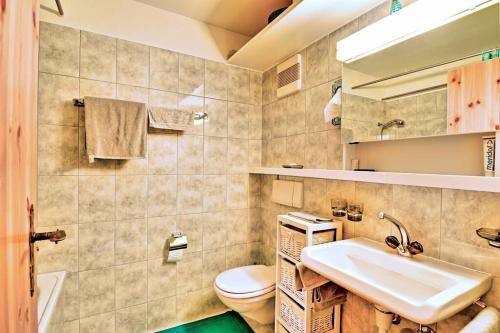 ein Bad mit einem Waschbecken und einem WC in der Unterkunft Stilvolle 2.5 Zimmer Wohnung nähe Skigebiet in Savognin