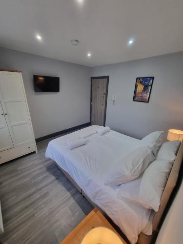a bedroom with a large white bed with pillows at Sussex apartments 26A in Grimsby