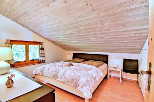 1 dormitorio con cama y techo de madera en Stilvolle 2.5 Zimmer Wohnung nähe Skigebiet en Savognin