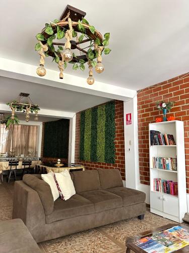 a living room with a couch and a brick wall at Hotel Sol de Canta in Canta
