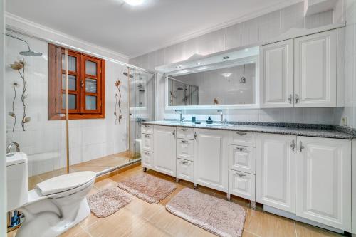 a white bathroom with a toilet and a sink at Two Seas Villa in Alanya