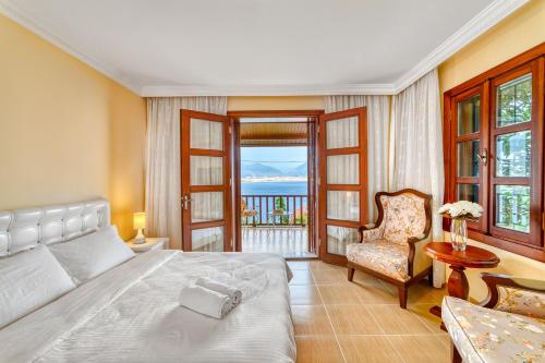 a bedroom with a bed and a chair and a window at Two Seas Villa in Alanya