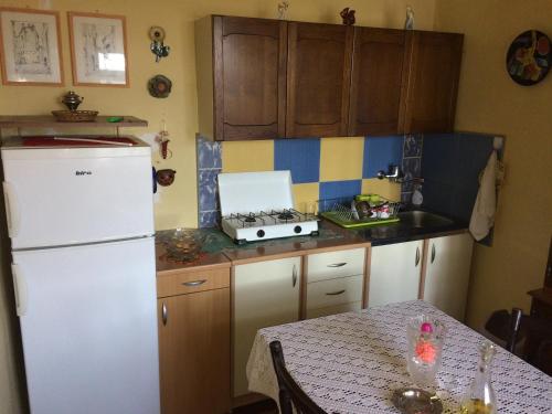 een keuken met een witte koelkast en een tafel bij Lanina kuca 