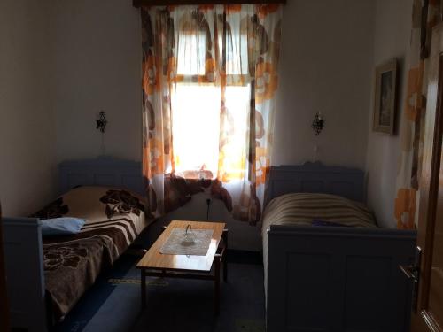 um quarto com duas camas e uma mesa e uma janela em Lanina kuca 