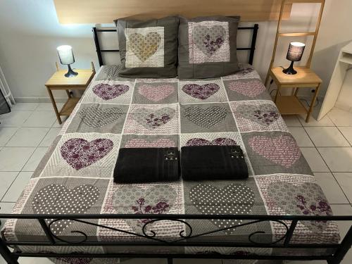a bed with a quilt with hearts on it at Casanova home in Saint-Denis