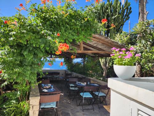 a patio with tables and chairs and flowers at Villa Bina Sea Hotel in Ischia