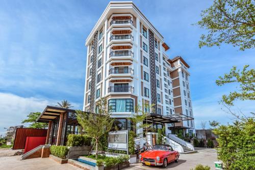 an apartment building with a red car in front of it at S Park Design Hotel in Vientiane