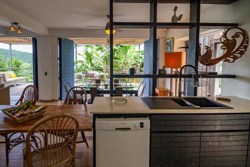 a kitchen and dining room with a table and chairs at Les Cabanes Perchées in Bouillante