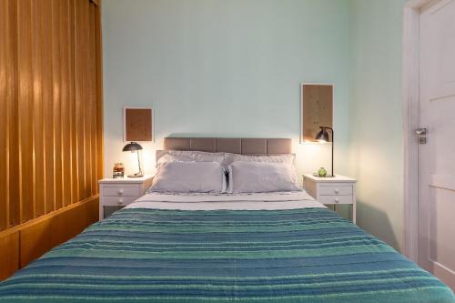 um quarto com uma cama grande e 2 mesas de cabeceira em Studio SOL de COPACABANA 300 m da Praia no Rio de Janeiro