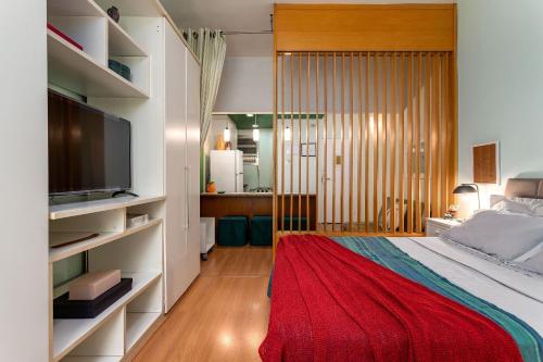um quarto com uma cama com um cobertor vermelho em Studio SOL de COPACABANA 300 m da Praia no Rio de Janeiro