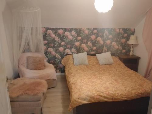 a bedroom with two beds and a floral wall at Apartament with nice city view in Dezmir
