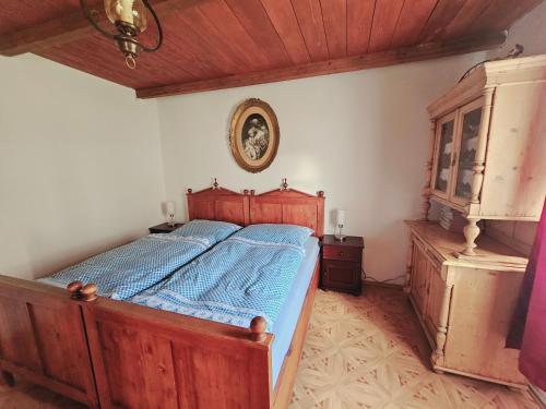 1 dormitorio con cama de madera y edredón azul en Stateček plný zvířátek 