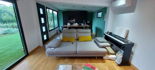 a living room with a couch and a piano at Cocon tout confort au coeur de la nature in Carnoules