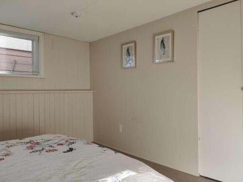 a bedroom with a bed and two pictures on the wall at John's House in Vancouver West in Vancouver