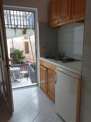 a kitchen with a sink and a dishwasher next to a window at Vila Sisevic in Budva