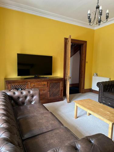 a living room with a couch and a flat screen tv at 4 Caberfeidh in Fort William