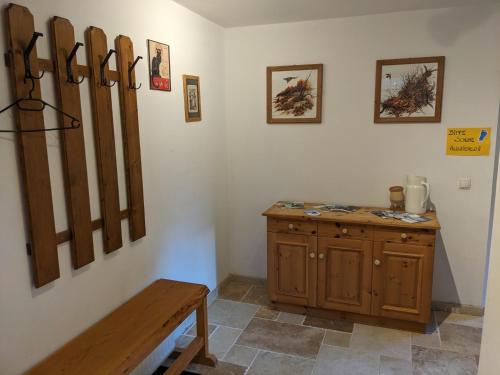 um quarto com um armário de madeira e um banco em Notlehenhof Ferienwohnung em Sellrain