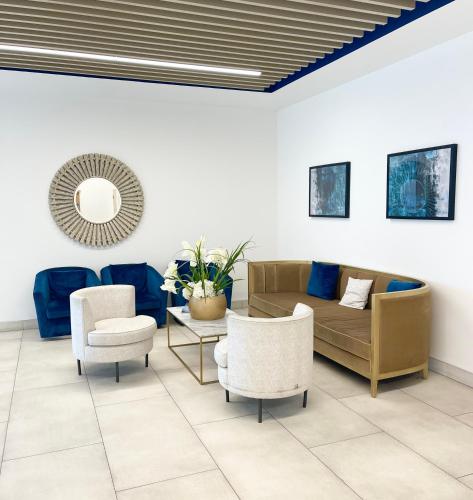a living room with a couch and chairs and a mirror at Urban Gateway Spacious Apartment with free parking in Bracknell