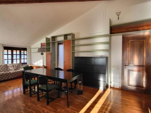 a dining room with a black table and chairs at Sentirsi a casa in Chiampo