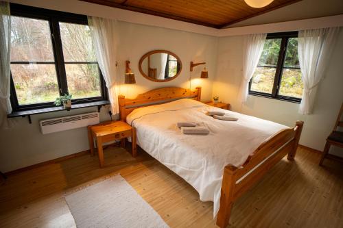1 dormitorio con 1 cama grande y espejo en Ferienhaus Smultronsställe Hjo, Vättern, en Hjo