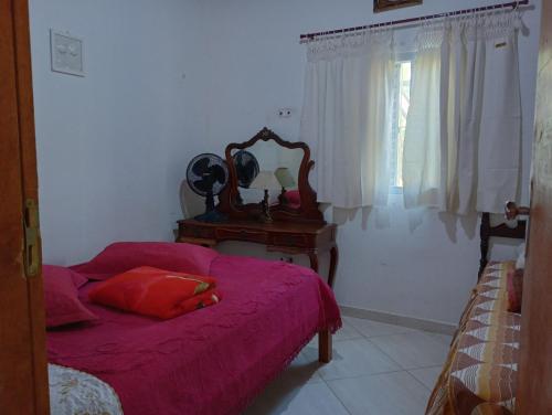 een slaapkamer met een bed en een tafel met een spiegel bij CHÁCARA TERRA dos SONHOS in Guaratinguetá