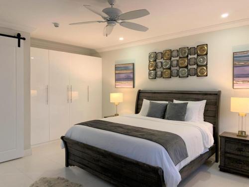 a bedroom with a large bed and a ceiling fan at Jamaica Bookings in Montego Bay