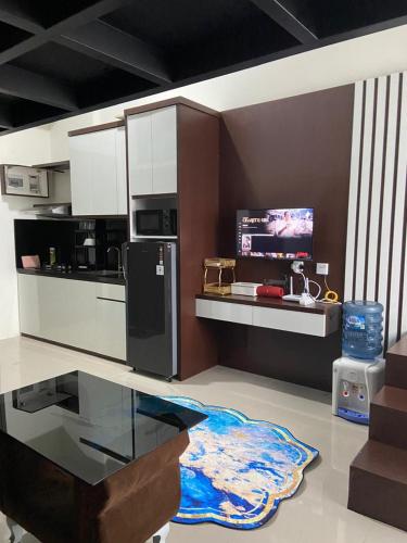 a kitchen with a black refrigerator and a glass table at Loft apartment bintaro in South Tangerang