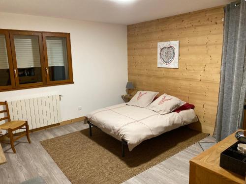 sypialnia z łóżkiem i drewnianą ścianą w obiekcie Chambre de la Tournette w mieście Saint-Jorioz