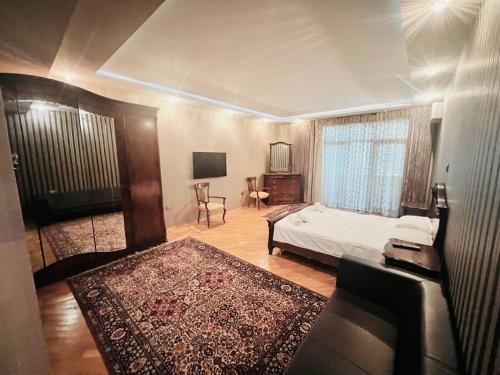 1 dormitorio con 1 cama y 1 habitación con TV en Azure residence, en Baku