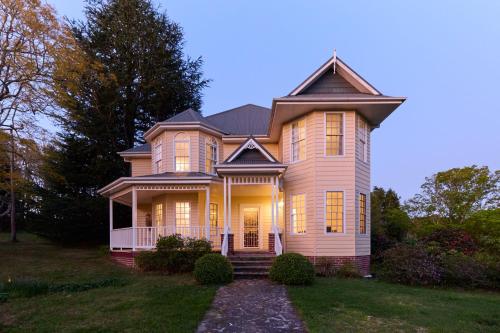 a large house with a porch on a lawn at The Folly in Bilpin
