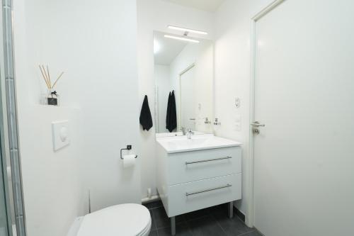 a white bathroom with a sink and a toilet at Noisy-le-Grand : Superbe appartement lumineux in Noisy-le-Grand