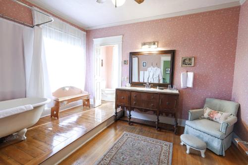 a bathroom with a tub and a mirror and a chair at Walnut Street Inn in Springfield