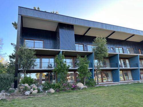 a blue building with a lawn in front of it at Apart Hotel Sol y Lago in Pucón