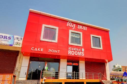 a red building with a sign on the side of it at OYO Hotel Pitra Chaaya Hotel And Restaurant in Mathura