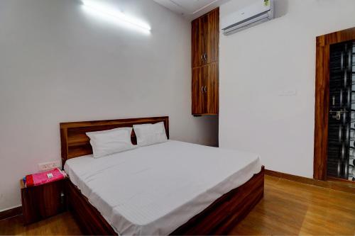 a bedroom with a large white bed in a room at OYO Hotel Pitra Chaaya Hotel And Restaurant in Mathura