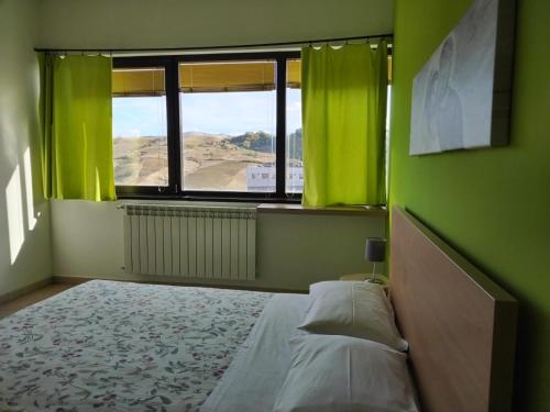 Un dormitorio con una cama con paredes verdes y una ventana en TWIN HOUSE en Tito