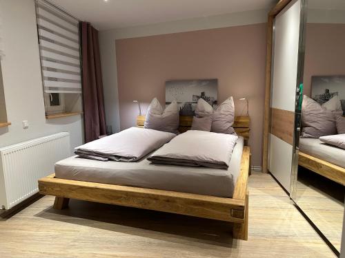 um quarto com uma cama grande e almofadas brancas em Lillis Cottage em Goslar