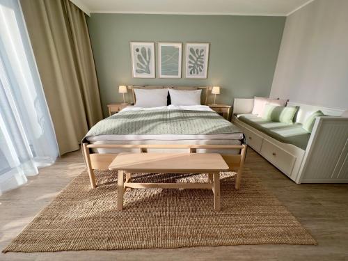 a bedroom with a large bed and a couch at Apartment Strandzeit in Kolpinsee