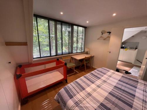 1 dormitorio con cama, escritorio y ventana en Private House ‘Het Dwerghuys’ - also longstays en Doorn