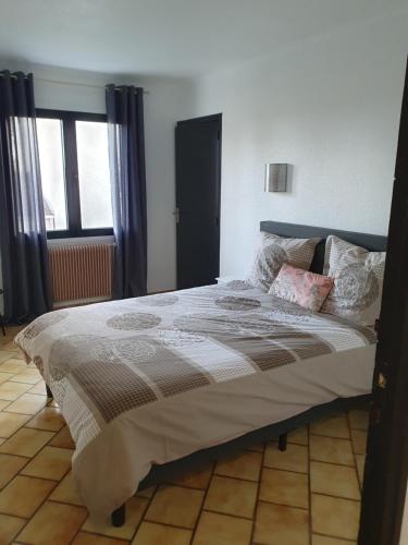 une chambre avec un grand lit dans une pièce dans l'établissement T4 Saint-Cyprien, à Saint-Cyprien