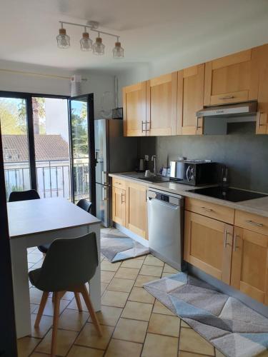 une cuisine avec des armoires en bois et un comptoir dans l'établissement T4 Saint-Cyprien, à Saint-Cyprien