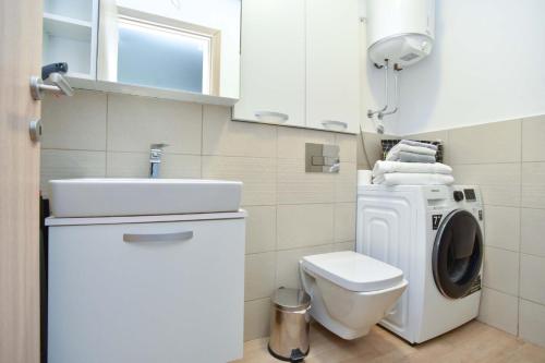 a bathroom with a washing machine and a sink at KAAN APARTMENT in Budva