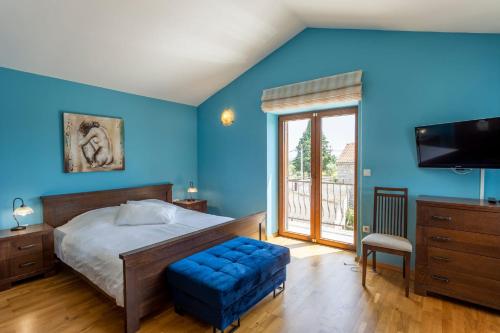 1 dormitorio azul con 1 cama y TV en Villa Lober, en Divšići