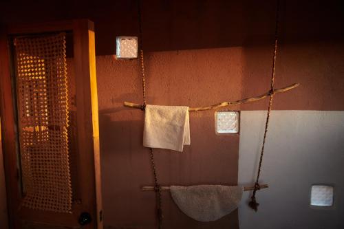 a bathroom with two towels hanging on a wall at Casa Chincol in San Pedro de Atacama