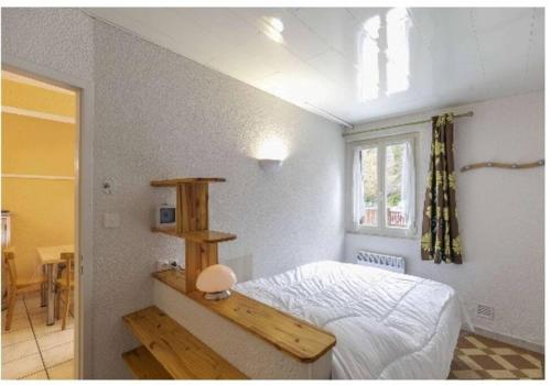 ein Schlafzimmer mit einem weißen Bett und einem Fenster in der Unterkunft Asphodèle, T2 bis, extérieur, wifi, parking, 6 personnes in Cauterets
