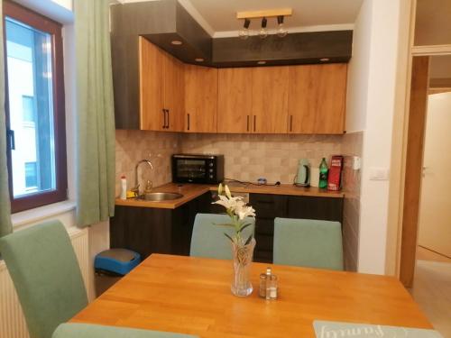 a kitchen with a table with a vase of flowers on it at Vila Akva in Jahorina