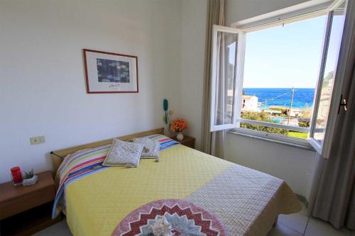 a bedroom with a bed and a large window at Hotel Holiday Bambù in Marciana