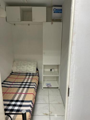 a small room with a bed and a cabinet at Partations For Rent in Dubai