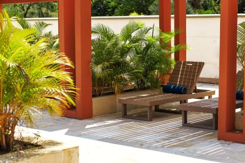 a wooden bench sitting on a patio with plants at Hotel Morúa in Yopal